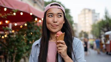 Woman enjoying ice cream while walking around outside