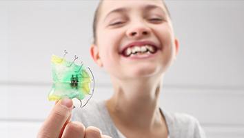 Teen girl holding retainer