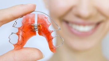 Closeup of woman holding retainer in Webster