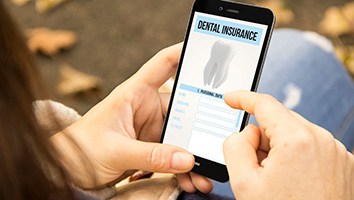 A woman looking at “Dental Insurance” screen on her phone